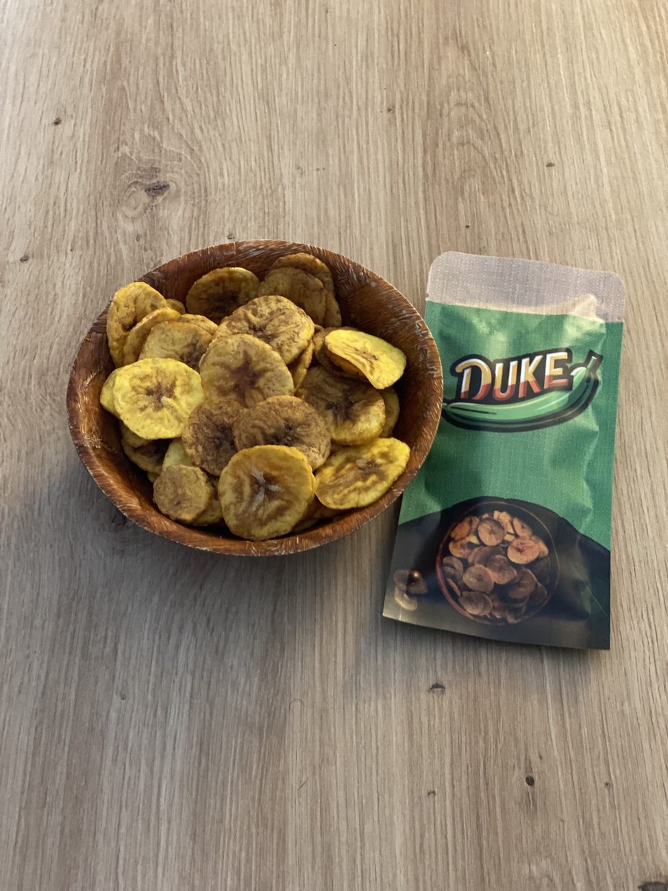 Chips de banane plantain Duke dans un bol, à côté d'un paquet